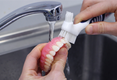 Use a denture brush to thoroughly clean your dentures